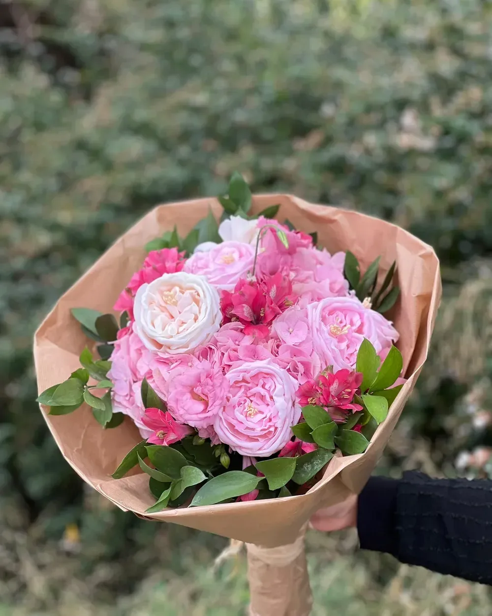 Kraft kağıda sarılı pembe ve beyaz kabarık çiçeklerden buket